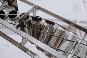 Close-up of metallic cans on a conveyor belt in an automated manufacturing facility.