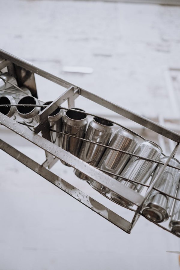 Close-up of metallic cans on a conveyor belt in an automated manufacturing facility.