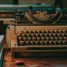 Close-up of a vintage typewriter on a wooden desk with classic design elements.