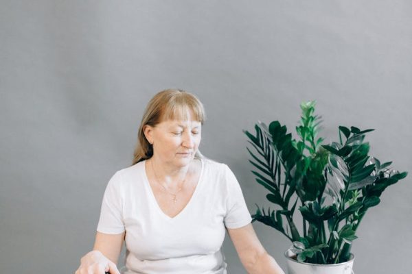 Elderly woman sits in yoga pose indoors, embracing mindfulness and relaxation.