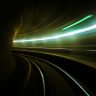 Blurred light streaks in a subway tunnel create a dynamic, futuristic effect.