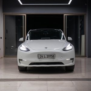 White electric car showcased in a minimalist indoor showroom with a contemporary design.