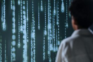 An individual viewing glowing numbers on a screen, symbolizing technology and data.